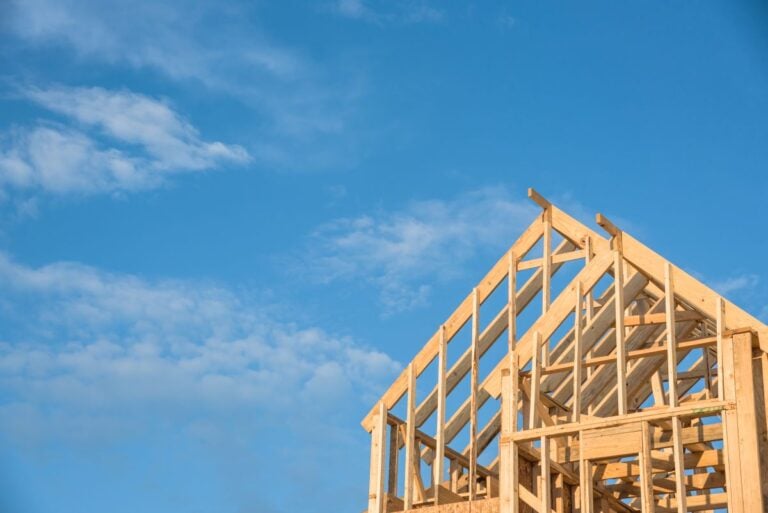 Close-up of gables roof on stick built home under construction and blue sky