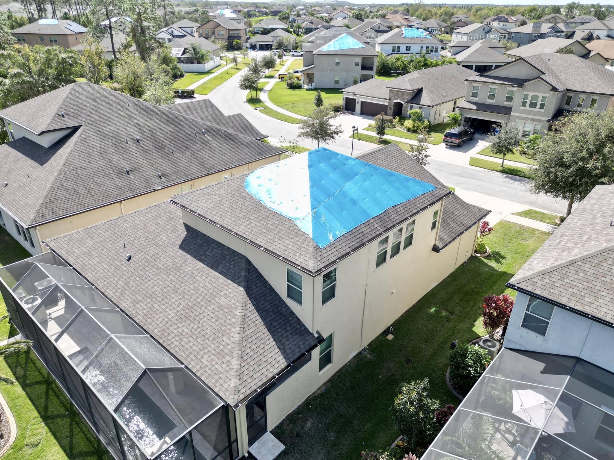 Roof with a blue tarp after storm damage