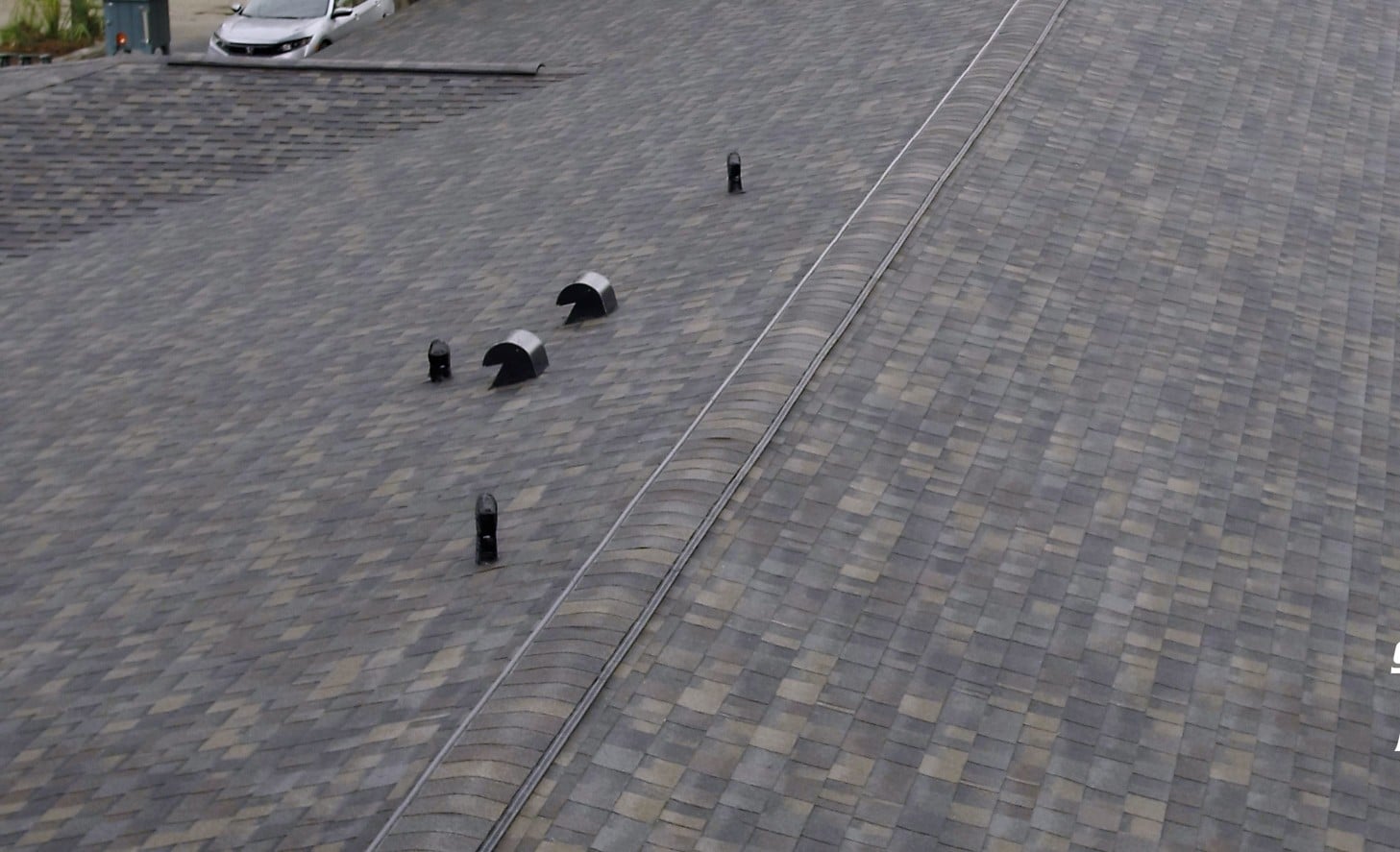 A close-up view of a sloped, shingled roof