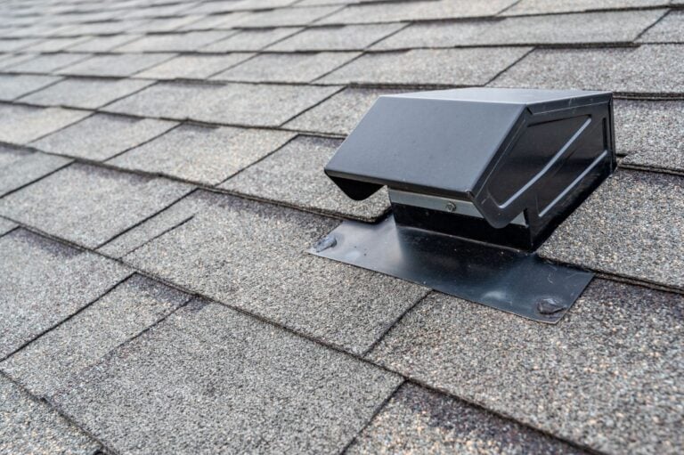 Close-up of a Slant Back Roof Vent installed on gray asphalt shingles, highlighting the detail of the vent, textured roofing material, and the performance benefits it brings to your roof.