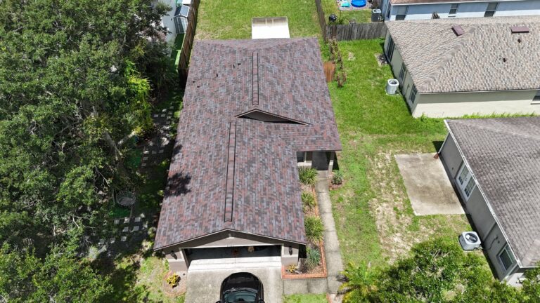 Aerial view of a single-story house with a brown asphalt shingle new roof after roof replacement