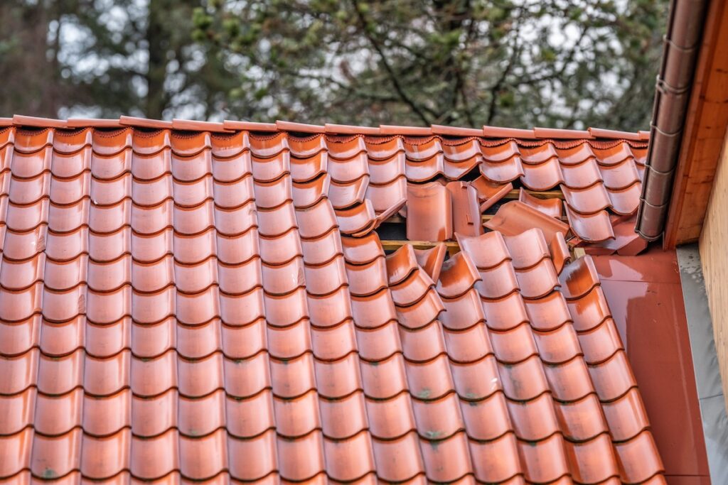 Damaged red roof tiles showing storm impact and structural wear
